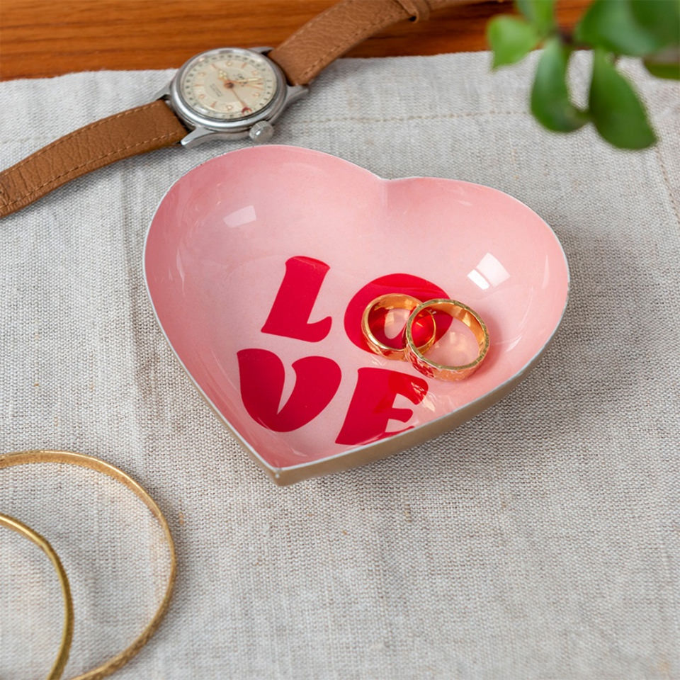 Pink heart-shaped LOVE trinket dish holding rings, lifestyle shot